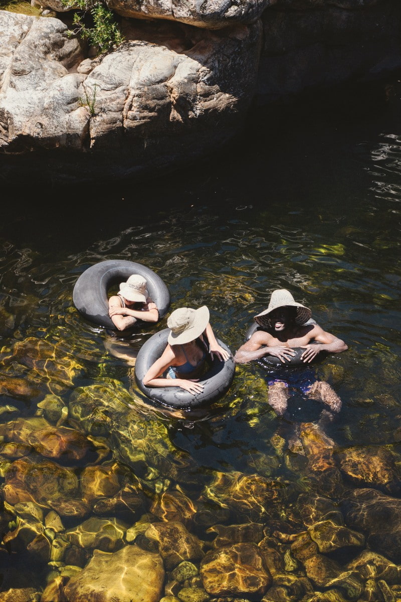 Three people floating on tubes in the river