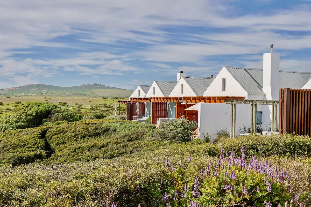External view of guest rooms with private patios overlooking coastal fynbos at Strandloper Ocean Boutique Hotel, Paternoster, West Coast South Africa