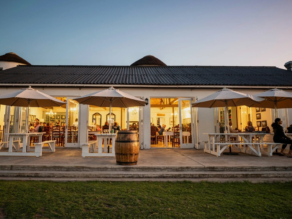 De Hoop Collection restaurant lit up at night is welcoming and relaxed.