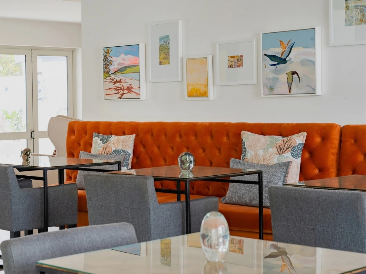 Breakfast room at One Marine Drive Boutique Hotel with a rust velvet bench in Hermanus
