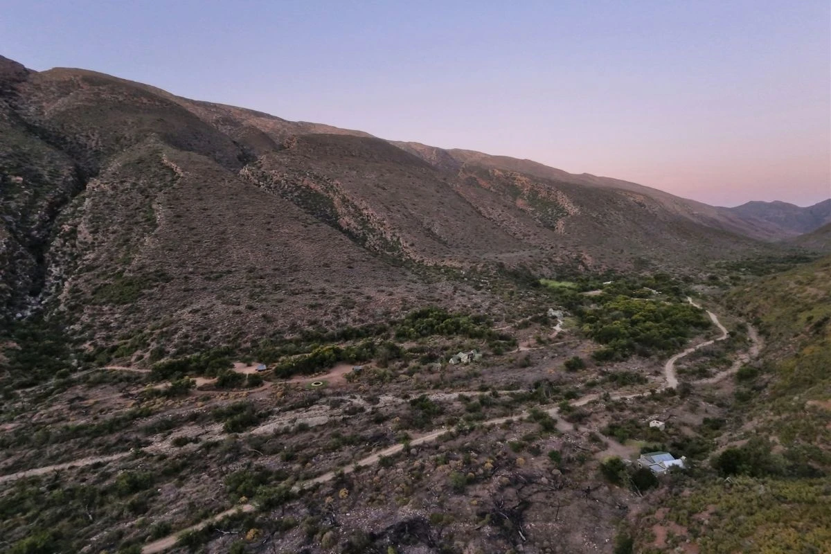 Aerial view of the Gamkaskloof valley in the Swartberg Nature Reserve, ringed by steep mountains with gravel roads below.